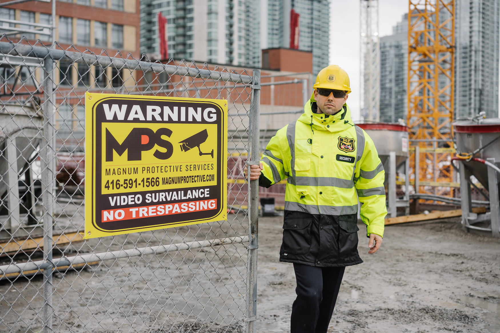 Construciton site guard at gate entrance with warning sign